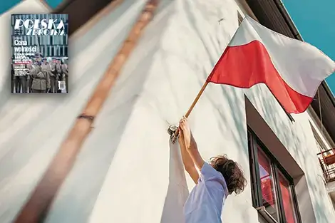 człowiek wiesza flage polski